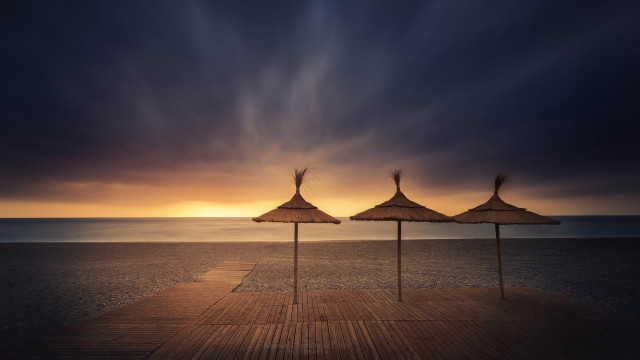 Umbrellas pier ocean sunset cloudy free wallpaper - medium preview image