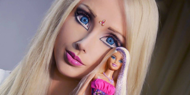 Barbie doll holding dolls in free wallpaper - medium preview image