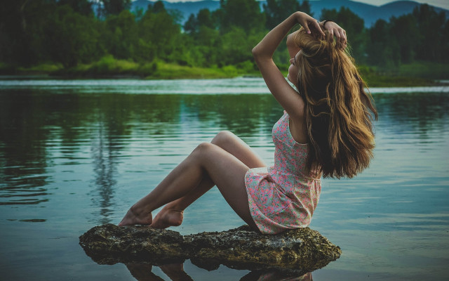 Woman sitting on rock beach free wallpaper - medium preview image