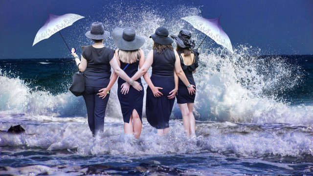 Stormy ocean girls umbrellas waves free wallpaper - medium preview image