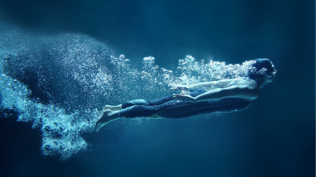 Man swimming ocean bubbles underwater free wallpaper - medium preview image