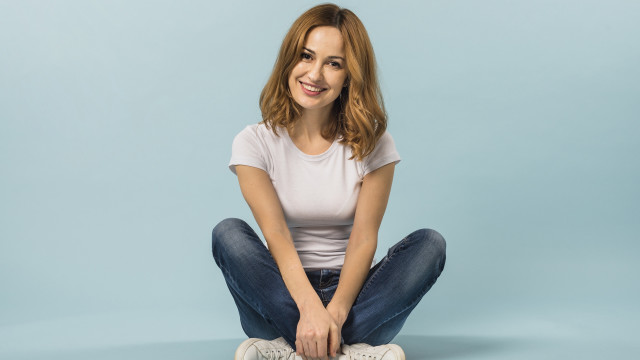 Woman sitting smiling blue background free wallpaper - medium preview image