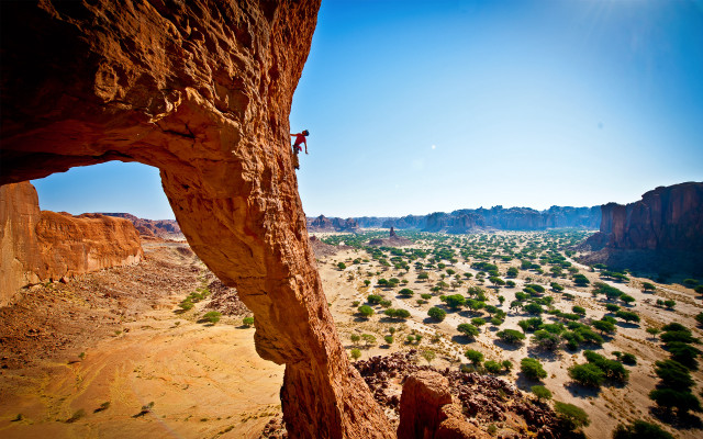 Man climbing cliff desert valley free wallpaper - medium preview image