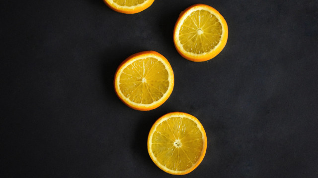 Oranges halved minimalist black surface free wallpaper - medium preview image