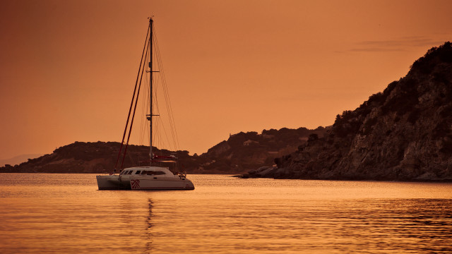 Sailboat rocky shore sunset mountain free wallpaper - medium preview image