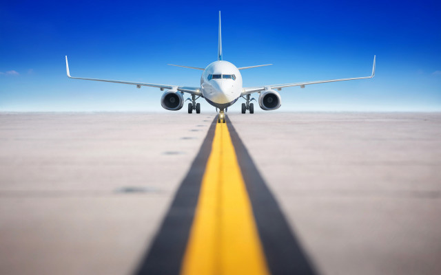 Large jetliner flying over runway free wallpaper - medium preview image