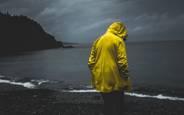 Man yellow raincoat beach ocean free wallpaper - medium preview image