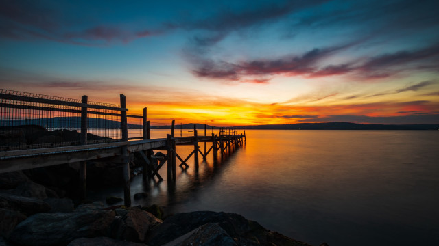 Sunset pier rocks water cityscape free wallpaper - medium preview image