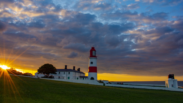Lighthouse grassy hill sunset clouds free wallpaper - medium preview image