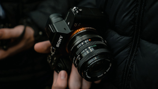 Person holding camera black jacket free wallpaper - medium preview image