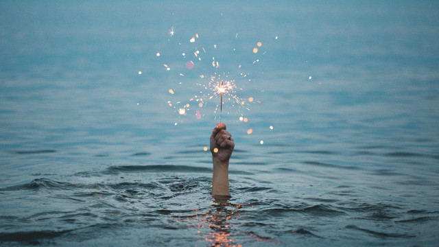 Hand sparkler water sky beach free wallpaper - medium preview image