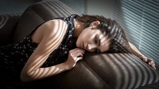 Woman couch lying somber blackhair free wallpaper - medium preview image
