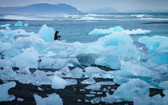 Man beach ice chunks mountains free wallpaper - medium preview image