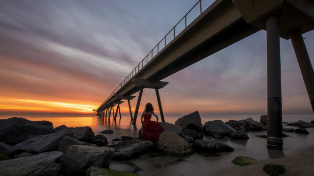 Woman rocks bridge sunset ocean free wallpaper - medium preview image