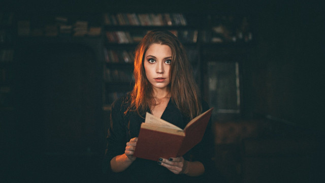 Woman holding book serious portrait free wallpaper - medium preview image