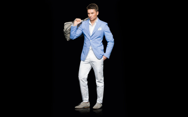 Man bluejacket whitepants holdingjacket camera free wallpaper - medium preview image