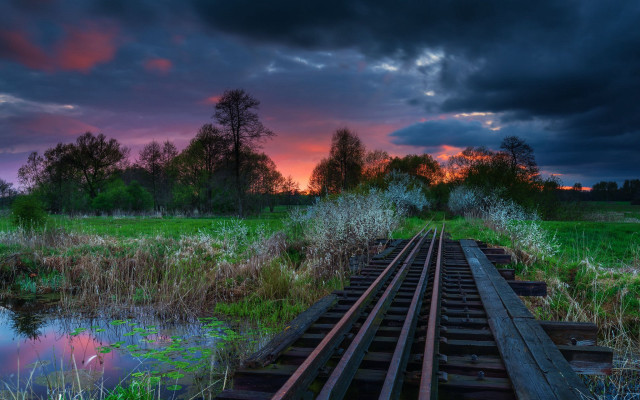Sunset train track grassy field free wallpaper - medium preview image