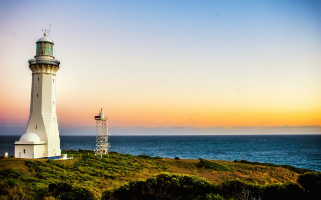 Lighthouse grassy hill ocean sunset free wallpaper - medium preview image