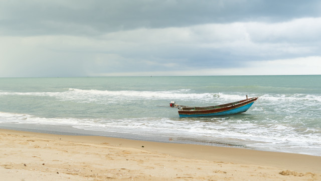 Stormy beach boat person sand free wallpaper - medium preview image
