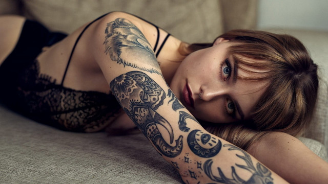Woman tattoo laying couch arm free wallpaper - medium preview image