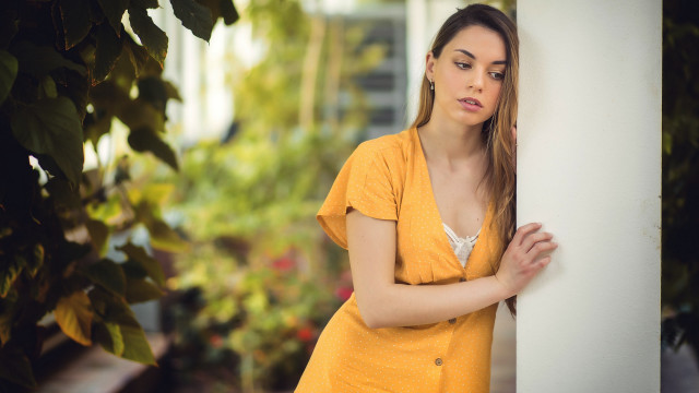 Woman leaning wall serious portrait #6 free wallpaper - medium preview image