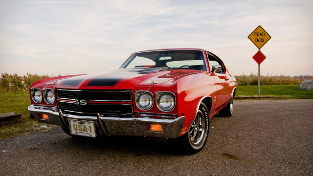 Red car yellow sign grass free wallpaper - medium preview image