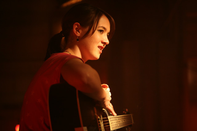 Woman guitar distance dark background free wallpaper - medium preview image