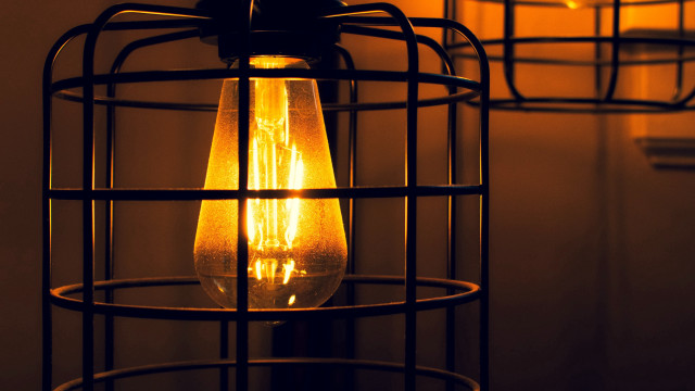 Lit bulb in caged fixture free wallpaper - medium preview image
