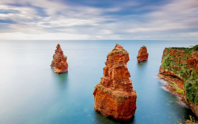 Rocky outcrop beach cloudy sky free wallpaper - medium preview image