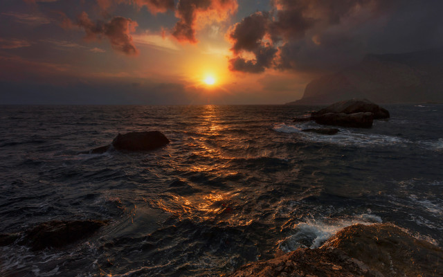 Sunset ocean rocky shore cityscape free wallpaper - medium preview image