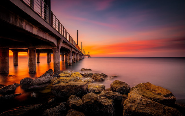 Pier sunset rocks water cityscape free wallpaper - medium preview image