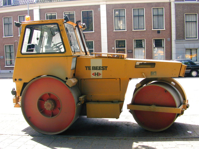 Yellow tractor parked street building free wallpaper - medium preview image