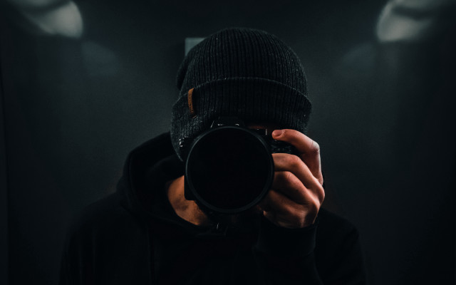 Man holding camera dark room free wallpaper - medium preview image