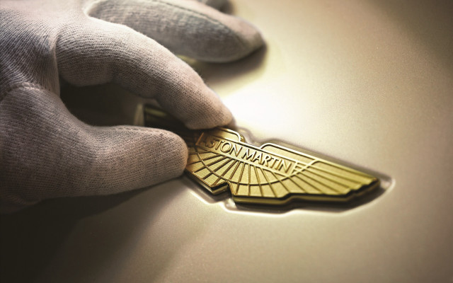 Gloved person gold emblem car free wallpaper - medium preview image