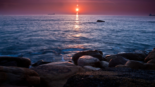 Sunset ocean boat rocks coastline free wallpaper - medium preview image