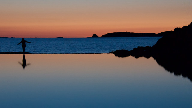 Person rock water sunset surfboard free wallpaper - medium preview image