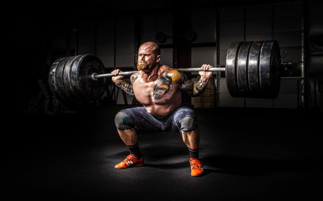 Muscular man squatting barbell dark free wallpaper - medium preview image