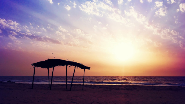 Beach sunset umbrellas clouds mountain free wallpaper - medium preview image