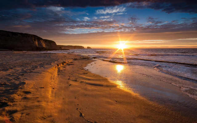 Sunset beach footprints cliff water free wallpaper - medium preview image