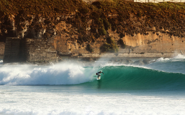 Surfer wave cliff beach city free wallpaper - medium preview image