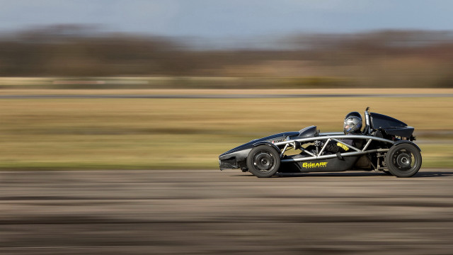 Black racecar driving road grass free wallpaper - medium preview image