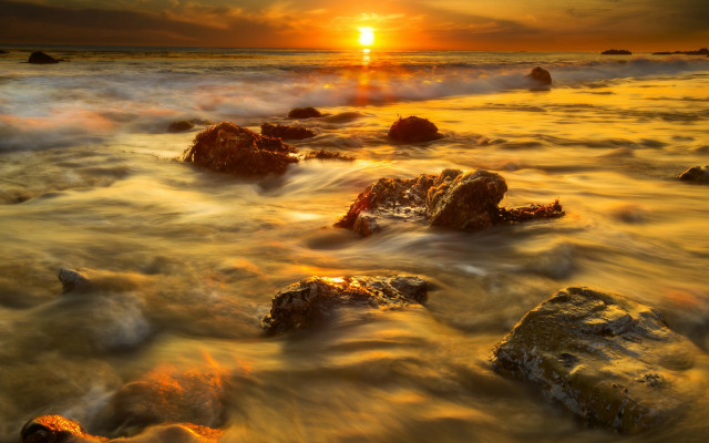 Sunset ocean rocks distant sun free wallpaper - medium preview image
