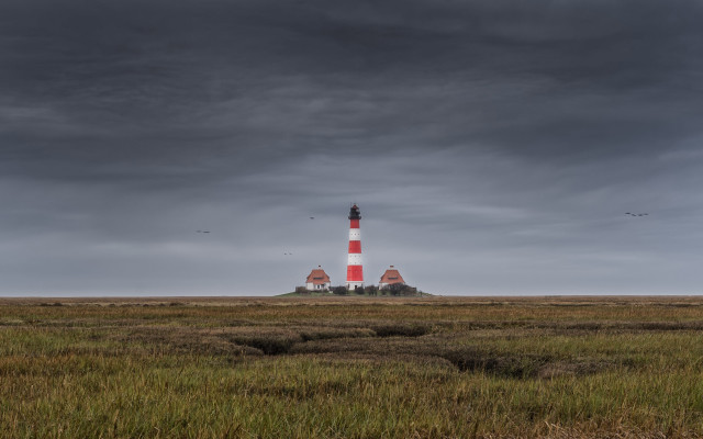 Lighthouse grassy island cloudy sky free wallpaper - medium preview image