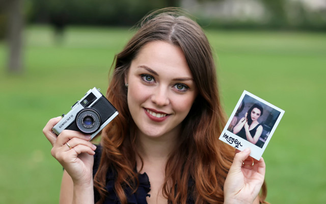 Woman holding polaroids camera portrait free wallpaper - medium preview image