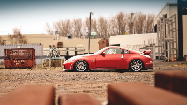 Red car parked building fence free wallpaper for desktop - medium preview image