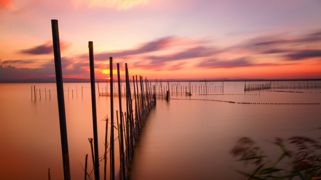 Beach poles sunset clouds ocean free wallpaper - medium preview image