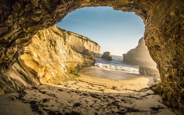 Cave ocean beach person sand free wallpaper - medium preview image