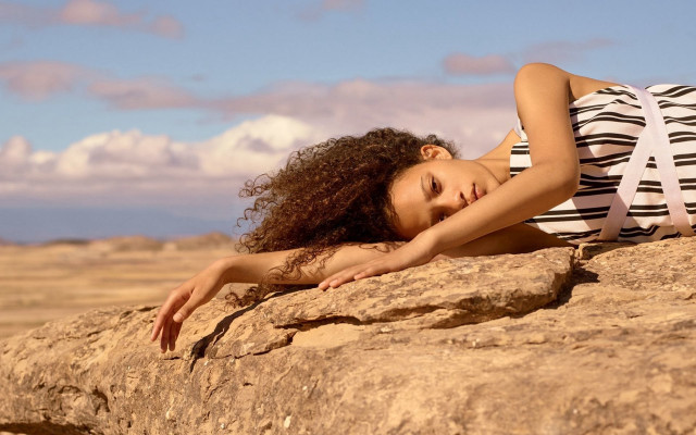 Woman rock stretching arm beach free wallpaper - medium preview image