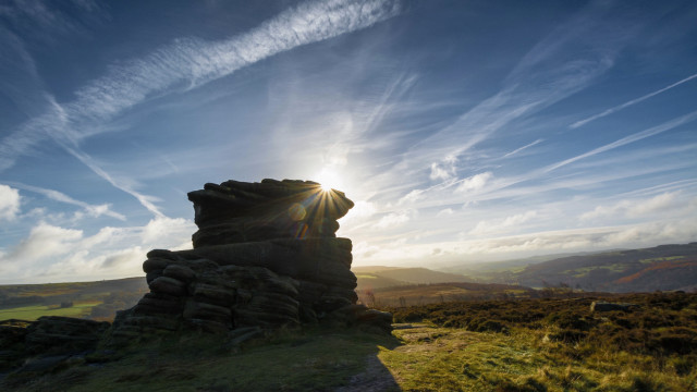 Rock formation grassy hill sunlight free wallpaper - medium preview image