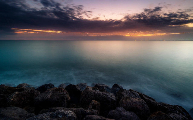 Rocky shore sunset water mountains free wallpaper - medium preview image